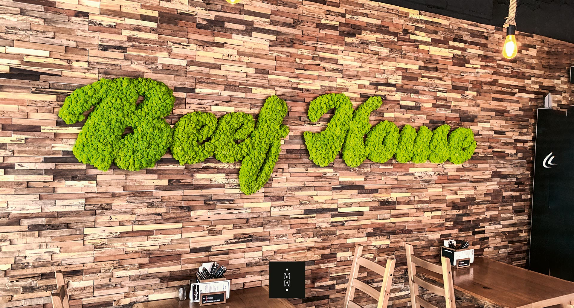 Logo des Restaurants Beef House aus apfelgrünem Isalndmoos an eienr Ziegelwand